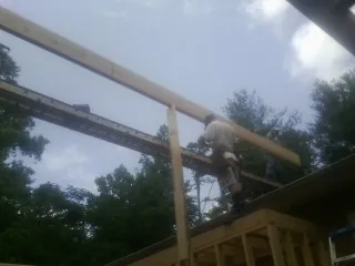 Carpenter setting a ridge beam over a new addition frame — Ice Dam Removal by Roofing Brothers in Buffalo Lake