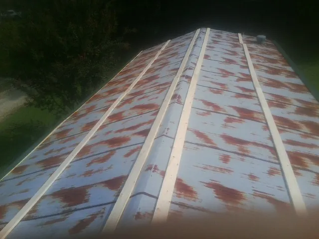 Rusted metal roof panels with new wood purlins before replacement — Storm Damage Roof Repair in Buffalo Lake by Roofing Brothers