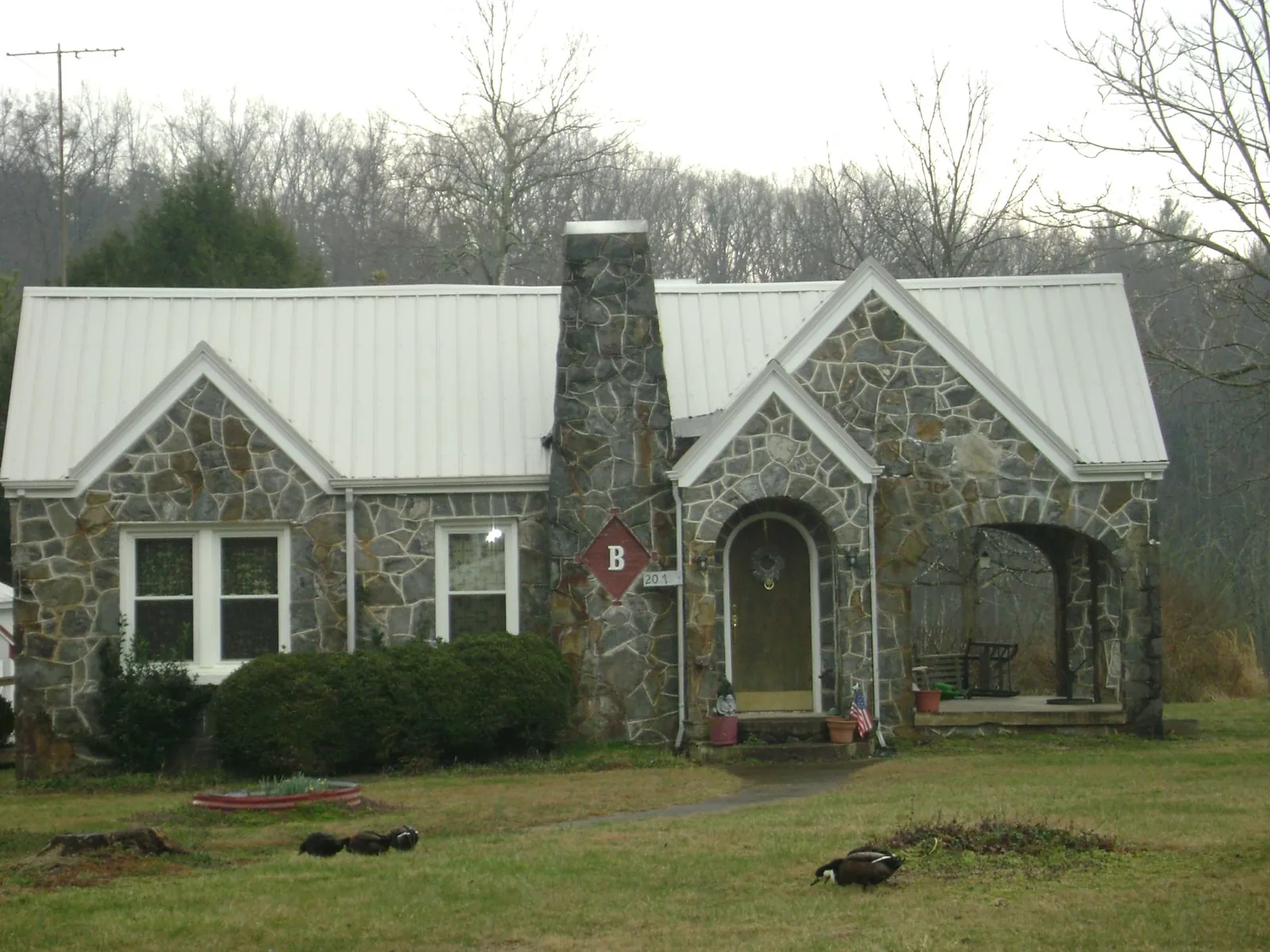 White metal roof on a stone cottage with steep gables in Buffalo Lake