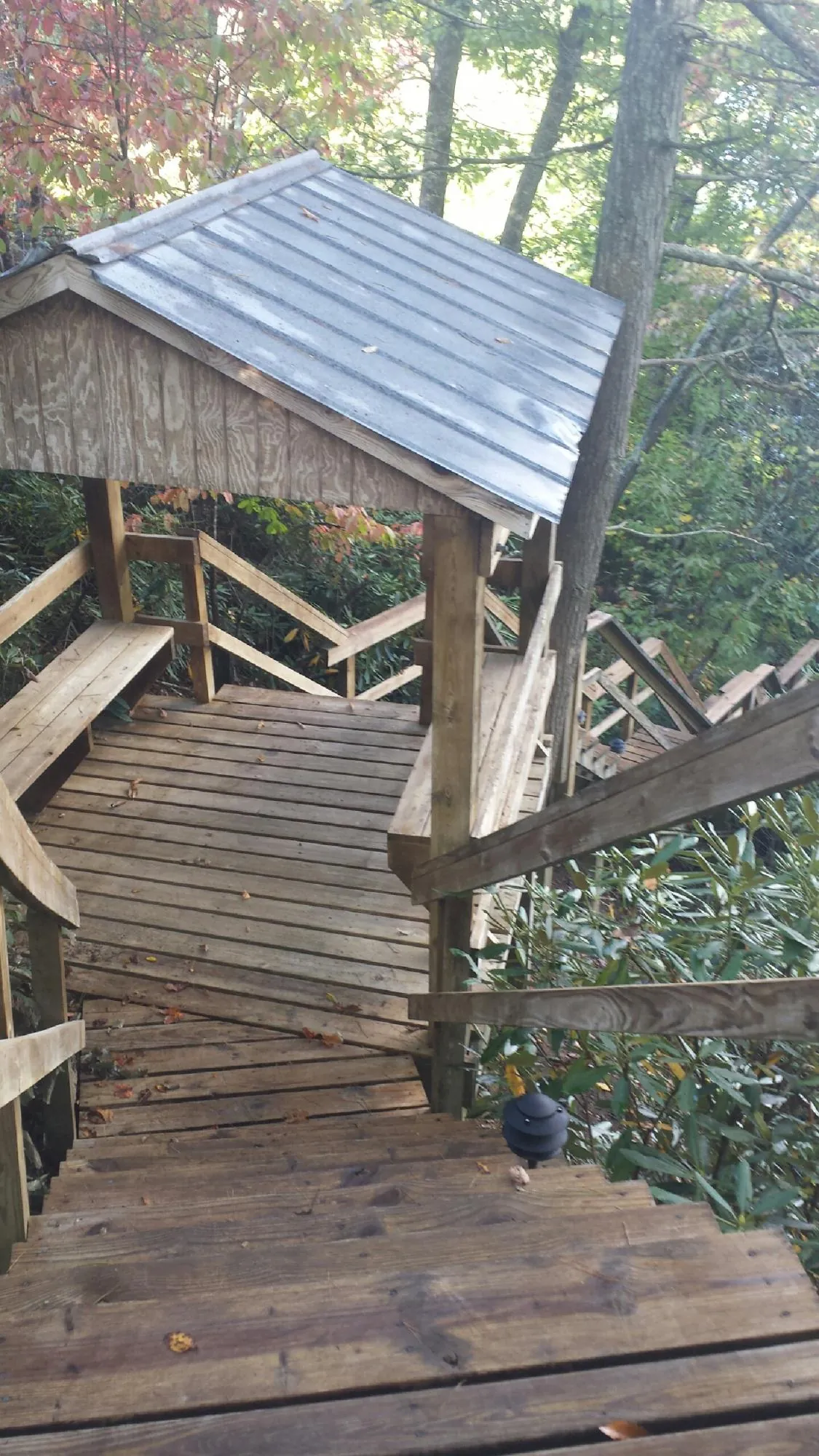 Metal roofed shelter over wooden steps on a wooded walkway — Skylight Repair & Installation work by our crew in Buffalo Lake
