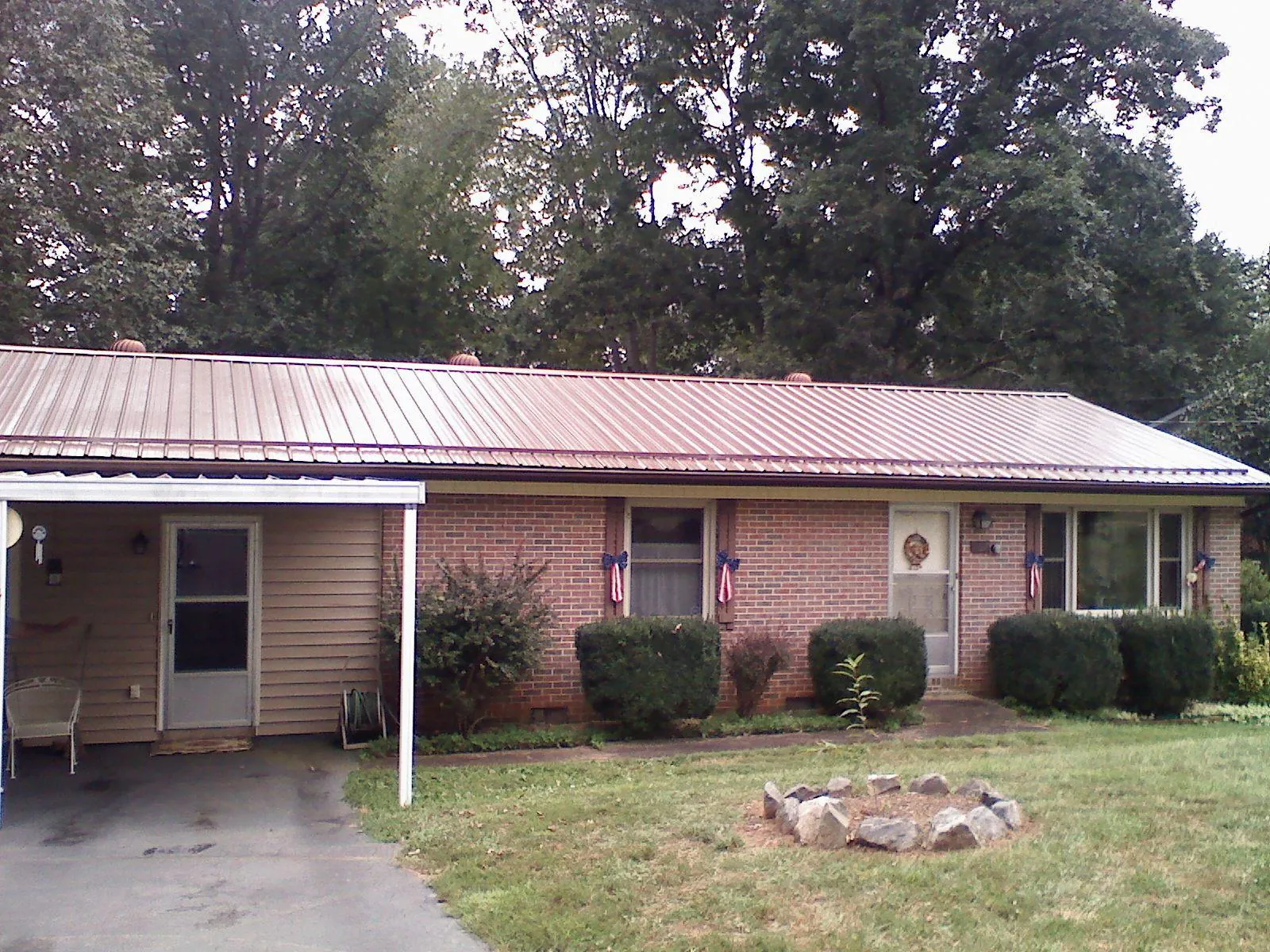 Bronze metal roof and carport on a brick ranch home — Roof Repair work by our crew in Buffalo Lake